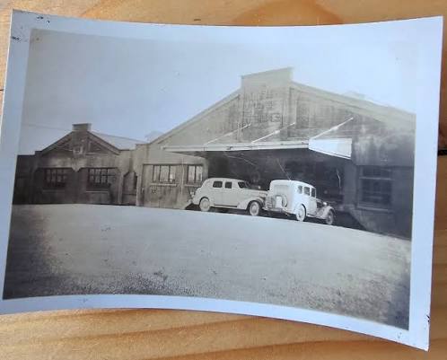 The Tauranga Dairy Company factory buildings in the 1930s, with vintage motor cars parked outside the entrance.
